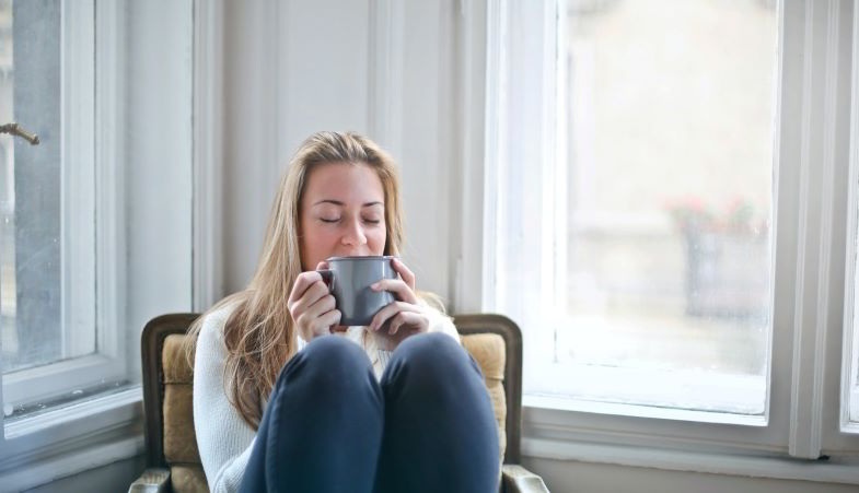 Chica bebiendo té de hierbas naturales para la ansiedad