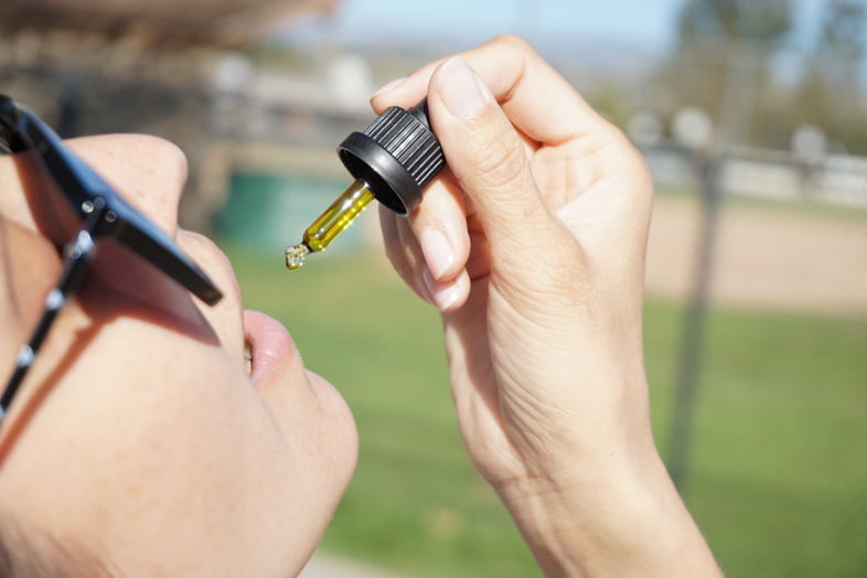 Mujer tomando gotas de extracto de Bedrocan