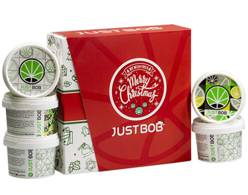 Caja de Justbob XMAS KIT abierta con varios contenedores de marihuana cbd, con marca navideña y diseño de hoja de cannabis, perfecta para regalos de Navidad
